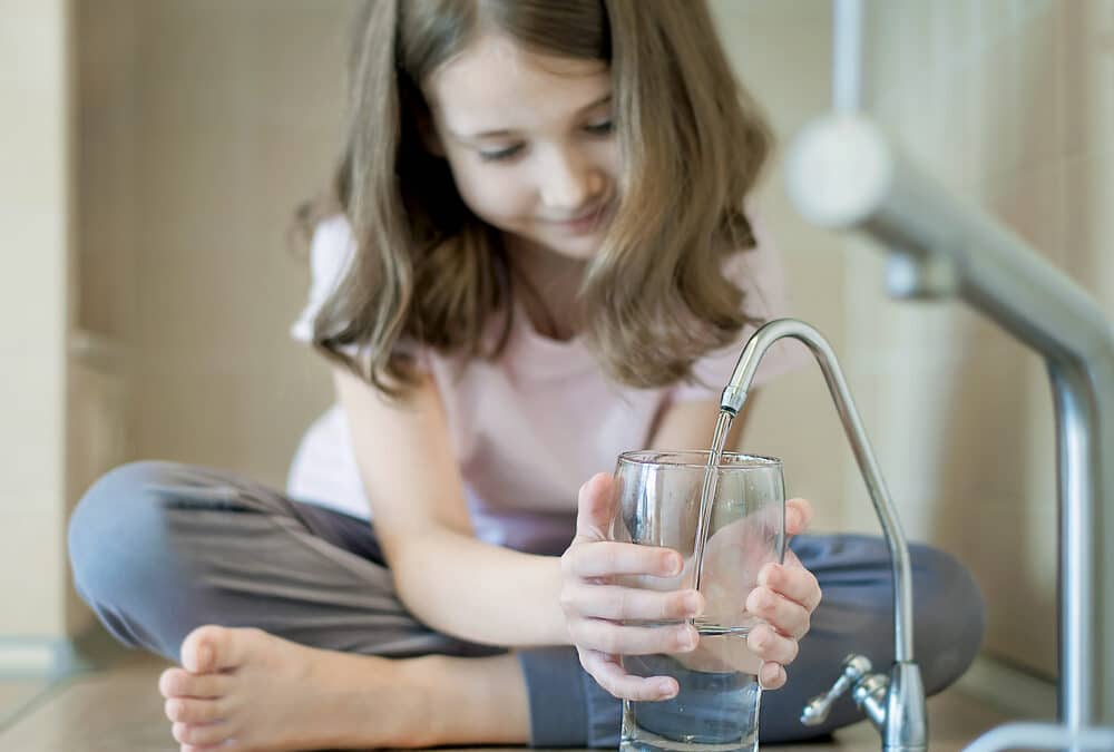 A family enjoying softened water and smiling happily.